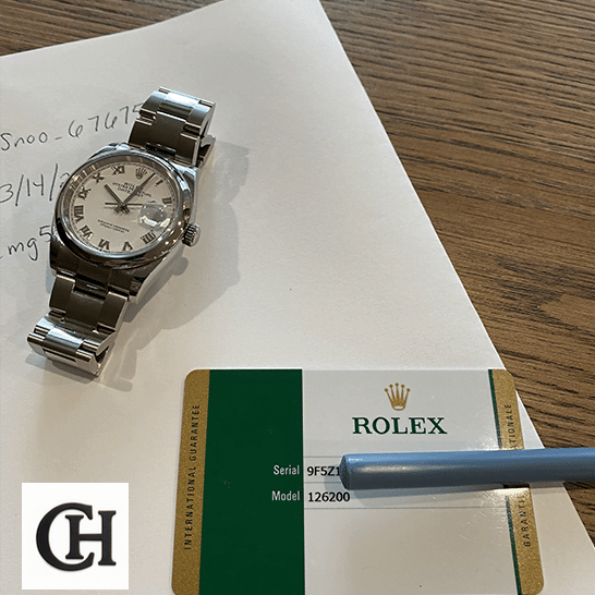 Rolex Datejust 126200-0008 White Dial rolex datejust 126200 0008 stainless Rolex datejust and warranty card on the table
